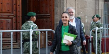 Sheinbaum ve a AMLO entregando la banda presidencial a una mujer