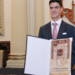 Jo Canales, preparador físico de Checo Pérez, recibe copia de la Cédula Real de Puebla