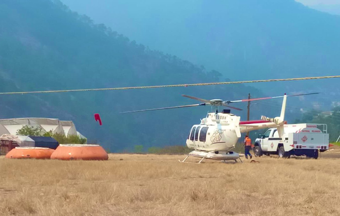 Dos aeronaves refuerzan combate a incendio forestal entre Aquixtla y Tetela